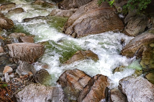 Preview: flowing river rushing over large boulders