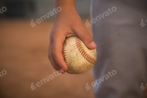 Preview: Cropped close up of boy's hand holding ball at baseball practise
