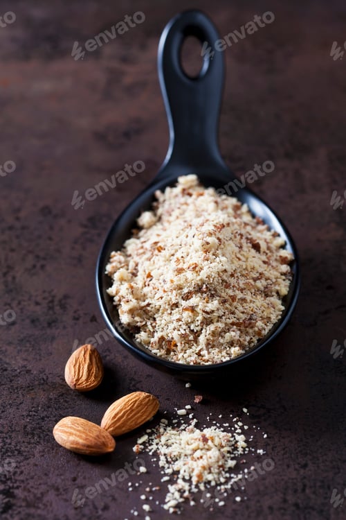 Preview: Spoon of almond flour and almonds on rusty ground