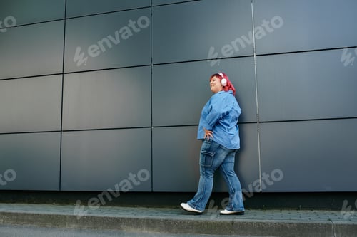 Preview: Woman in Blue Denim Walks by Wall
