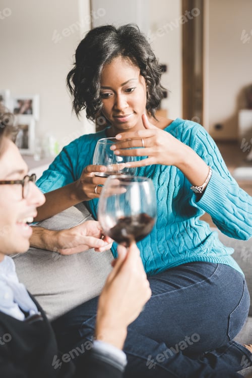 Preview: Young handsome mixed race couple in their house having a glass of red wine