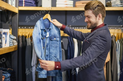 Preview: Shot of a young man looking at clothes in a boutique