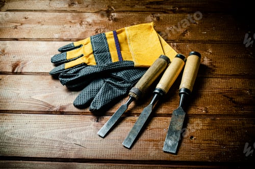Preview: Chisel with construction gloves on the table.
