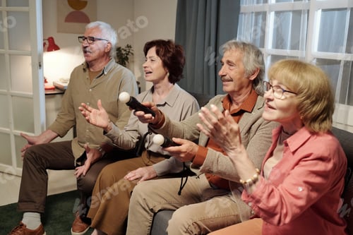 Preview: Row of senior friendly men and women sitting on sofa and playing video game