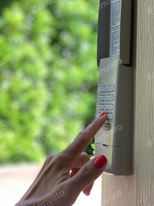Preview: Woman using a security code in exterior keypad garage door opener.
