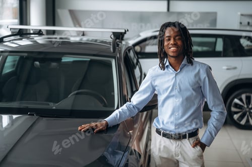 Preview: Front view. Car seller, businessman is standing in automobile salon