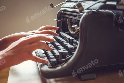 Preview: woman hands type on an old vintage dust-covered typewriter