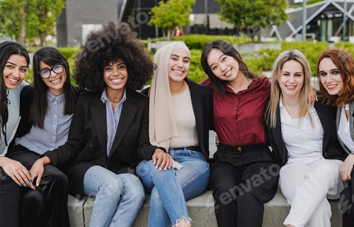 Preview: Young diverse business women sitting outdoor while smiling on camera