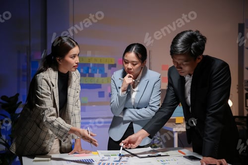 Preview: Businesspeople working late in the office analyzing financial charts and business data