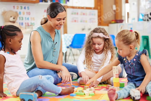 Preview: Teacher and kids looking happy while doing activity at kindergarten or pre-school. Smiling teacher