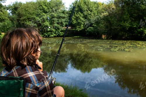 Preview: Boy fishing by lakeside, Bournemouth, UK
