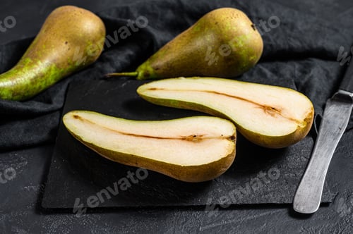 Preview: Pears and pear halves. Farm eco fruits. Black background. Top view. Space for text
