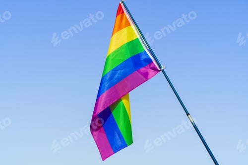 Preview: LGBT waving flag in the sky on flagpole