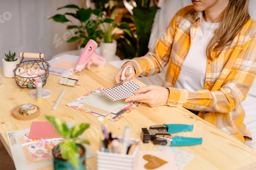 Preview: Woman Crafting Paper at Table with Craft Supplies