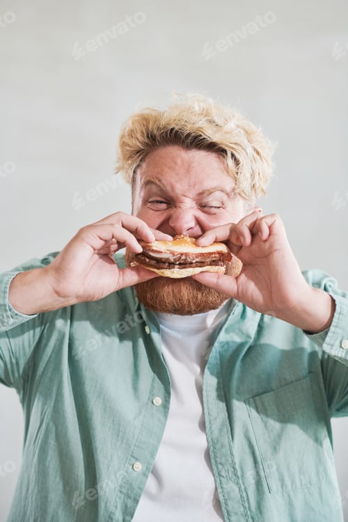 Preview: Overweight man eating burger