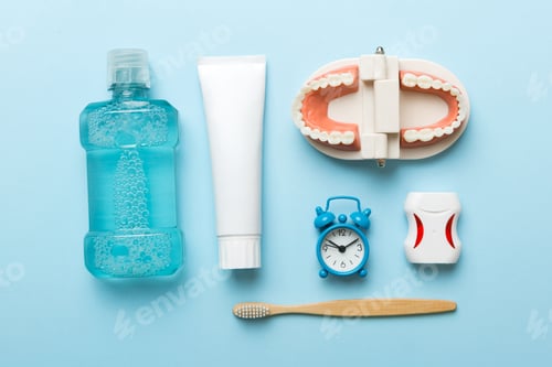 Preview: Mouthwash and other oral hygiene products on colored table top view with copy space