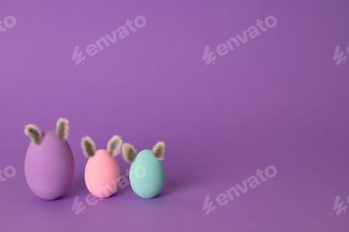 Preview: Easter eggs on a purple background with copy space. Side view mockup template. egg with ears