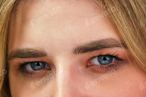 Preview: Close up blue eyes of an attractive blond girl.