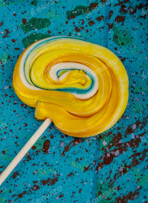 Preview: side view of colorful round lollipop on blue background