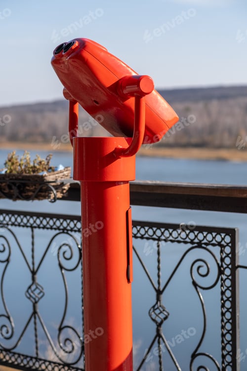 Preview: Public stationary binoculars on the banks of the river in summer