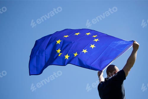 Preview: Man with EU flag over blue sky