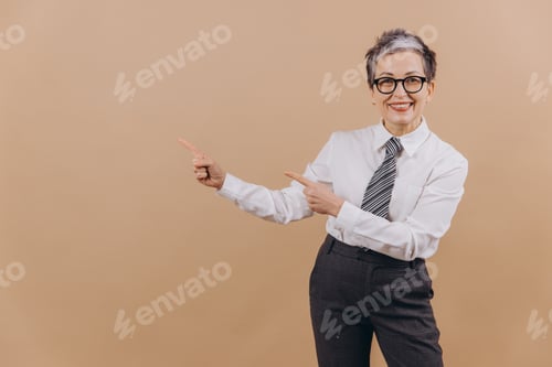 Preview: Mature businesswoman pointing to empty space for content