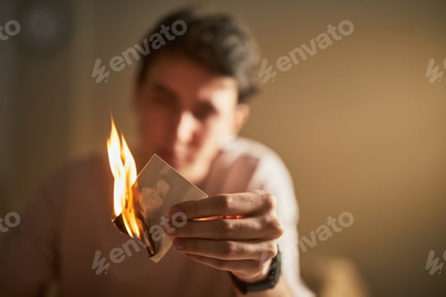Preview: Young Caucasian Man Burning Photograph While Expressing Intense Emotion