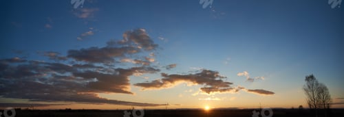 Preview: Sun sets low on horizon, casting golden glow across landscape.