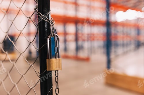 Preview: Secure Padlocked Fence in an Empty Warehouse with Metal Shelving Units