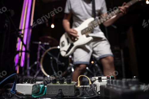 Preview: Close-up set of distortion effect pedals for guitar on stage.