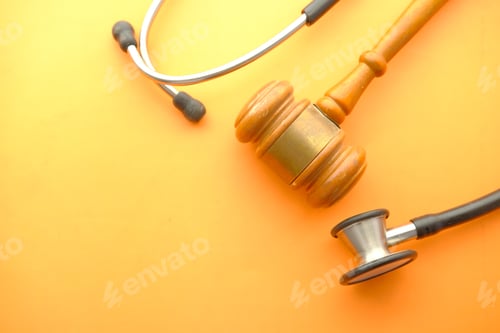 Preview: Top view of gavel, stethoscope and pills on orange background