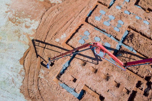 Preview: A worker pours concrete into the house foundation using a concrete pump