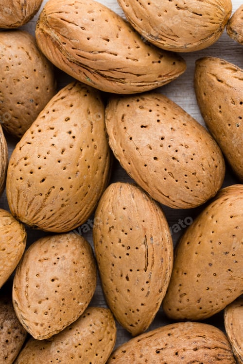 Preview: Group of almond nuts with leaves.Wooden background.