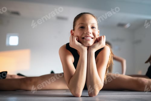 Preview: Group of fit happy children exercising ballet in studio together