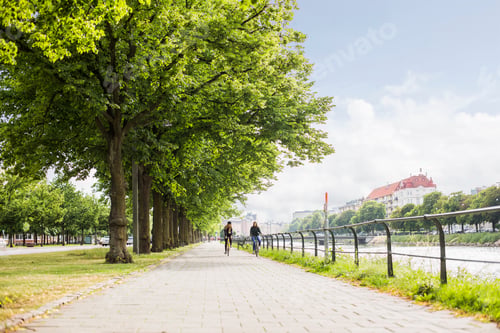 Preview: Two young women riding bicycles along river