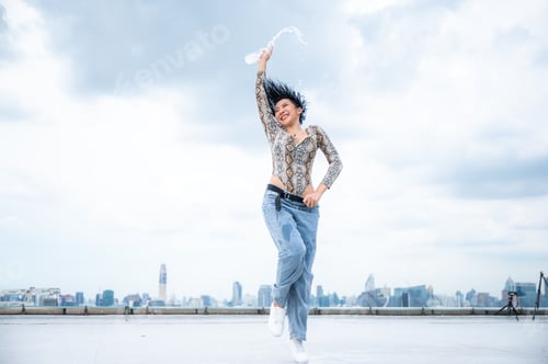Preview: Young hip hop woman dancing on city background.