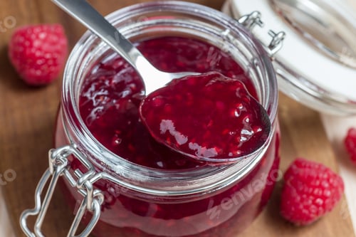 Preview: Raspberry jam in glass jar on a wooden board, horizontal
