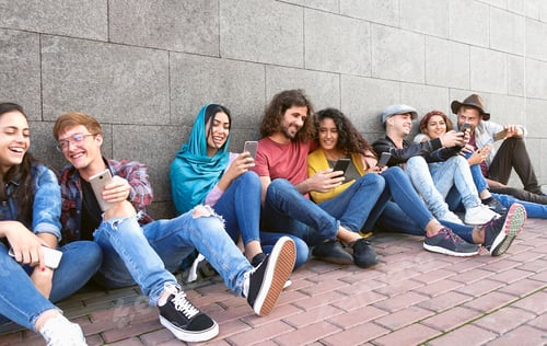 Preview: Young multiracial group of friends using mobile smartphone outdoor