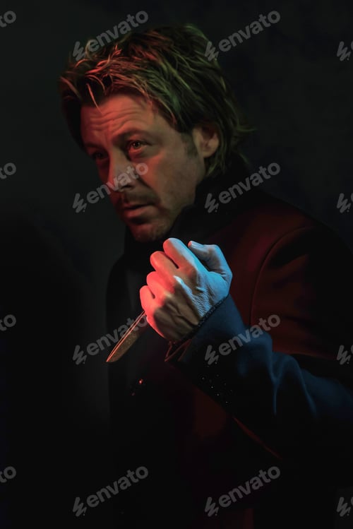 Preview: Scary Man With Scissors In Hand Illuminated By Red And Blue Light.