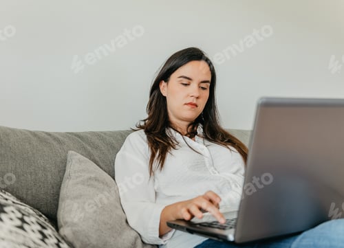 Preview: Woman Working on Laptop Computer While Relaxing at Home