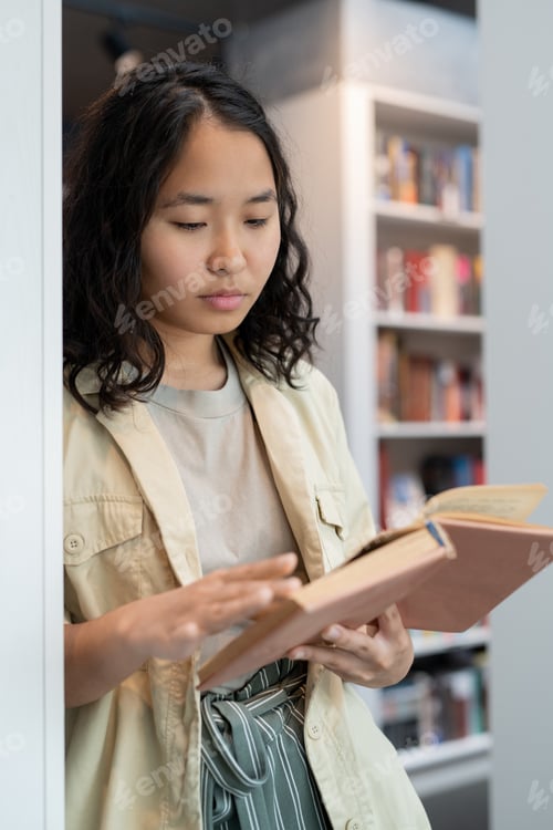 Preview: Clever student of college reading book in library