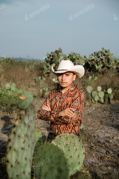 Preview: young man with mexican hat in a desert landscape with cactus