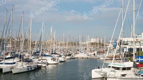 Preview: Serene marina with numerous sailboats docked on a clear day