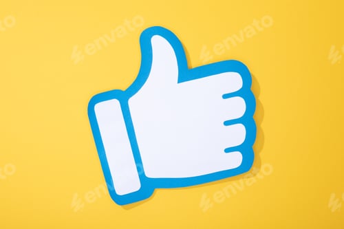 Preview: top view of white paper hand with thumb up on yellow background