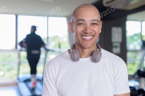 Preview: Confident bald Hispanic man posing in gym, fitness and strength-focused lifestyle portrait