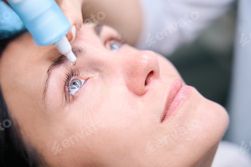 Preview: Qualified oculist preparing adult woman for retinal exam