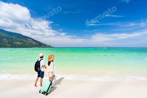 Preview: Young couple traveler with luggage relaxing and enjoying at beautiful tropical sand beach