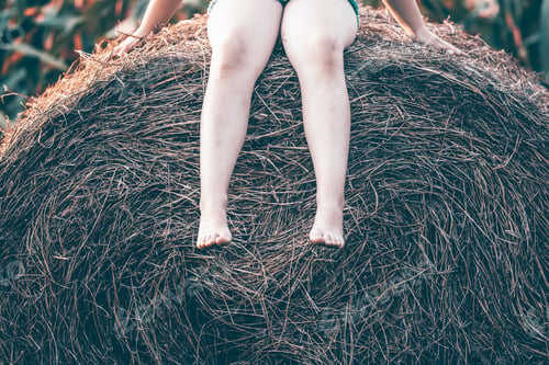 Preview: Legs of a child, sitting on a haystack