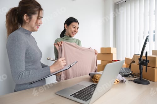 Preview: Two Asian entrepreneur women take order and check boxes of products according to customer orders in