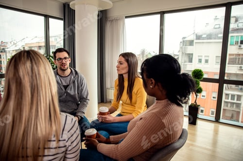 Preview: Diverse group of people sitting in circle in group therapy session.